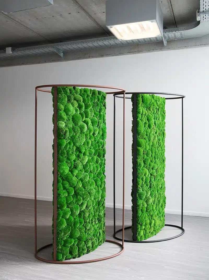 Twee verticale groene mospanelen in metalen frames.